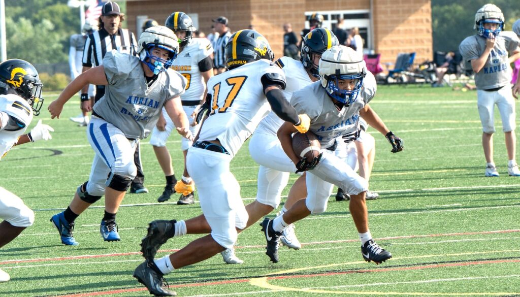 Adrian’s Javion Fire breaks away from Lansing Waverly defenders during an Aug. 21 scrimmage at Dexter. (Photo by Lad Strayer)