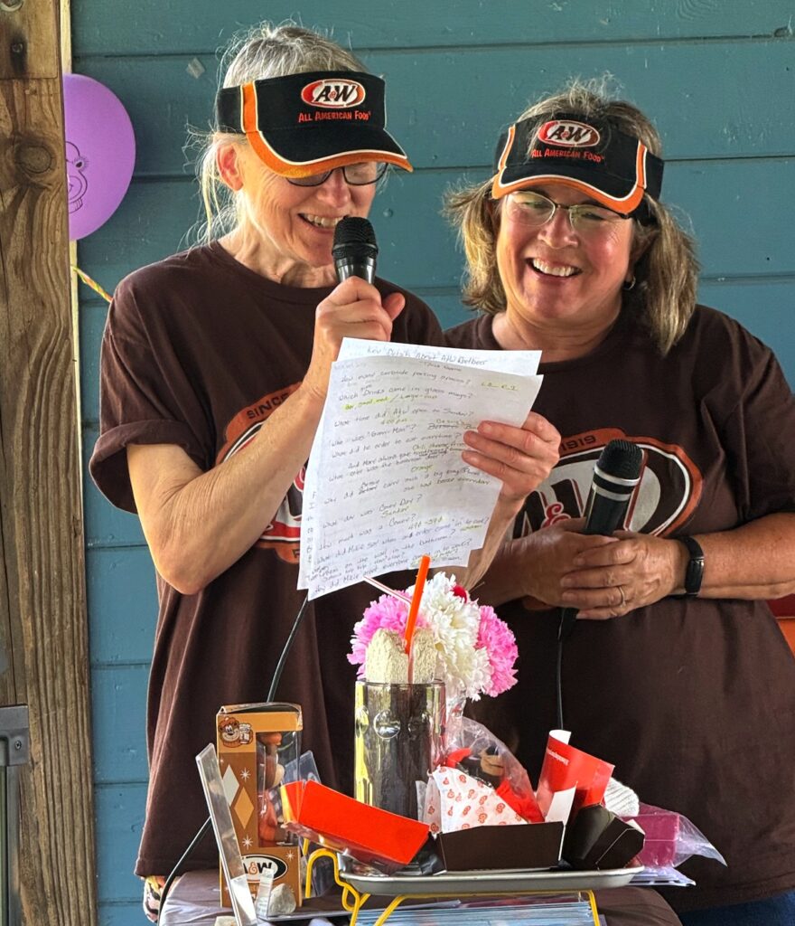 Mikie Rion and Renee Stewart read quiz questions at the Adrian A&W reunion.