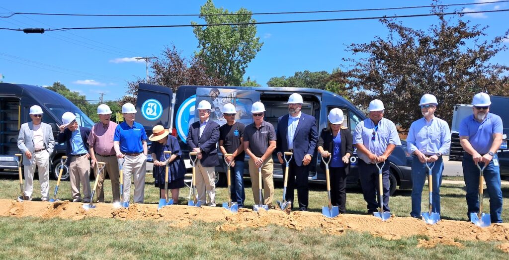 Pictured at the July 23 groundbreaking for Adrian Steel’s new 112,000-square-foot expansion are Joe Emens, Lynn Baugh, Norm Brandeberry, Harley Westfall, Marnie Dilworth, Don Delong, Tyrel Hill, Rick Brandeberry, Marc Jackson, Kathy Westfall, Bob Stephan, Jim Morgan, and Dave Westphal. (Photo by Deborah J. Comstock)
