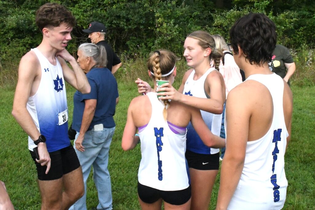 Adrian's Ayda Skeels and Madison Petty celebrate at the end of the Lenawee County preview meet on Aug. 22.