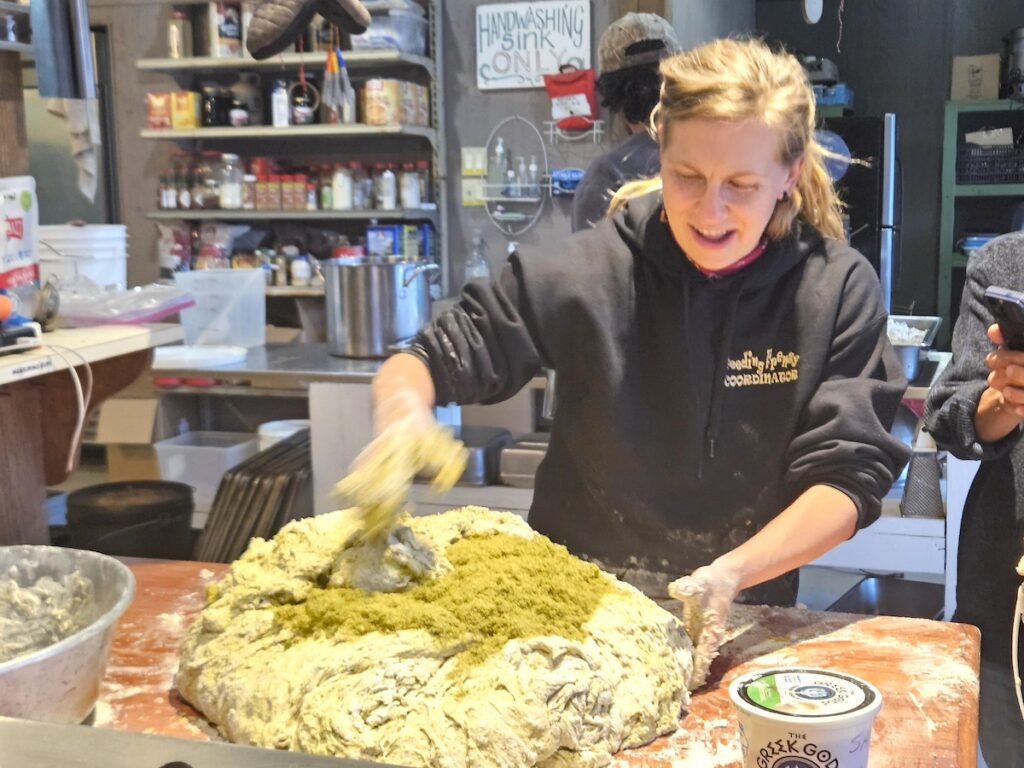 Colleen Perria kneads a massive ball of dough to prepare a meal at the Great Lakes Foragers Gathering.