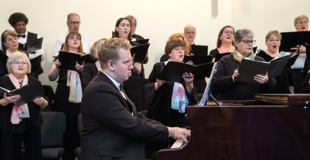 Pianist Isaac Cox, foreground, accompanies the Lenawee Community Chorus during a recent concert.