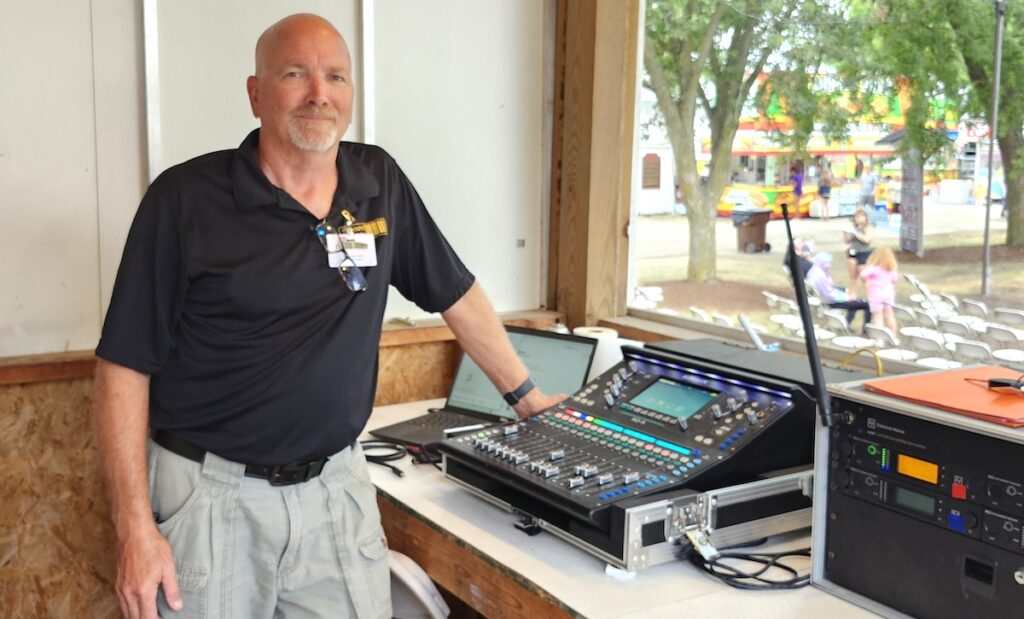 Mike McLemore stands at the sound board at the Lenawee County Fair bandshell on Aug. 1, the last day of the 2026 fair. (Photo by Erik Gable)