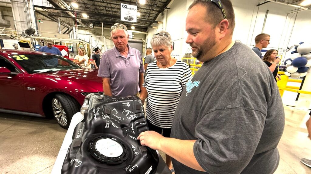 Employee Keith Allen, right, shows his parents, Dick and Lynn Allen, a fuel tank for a Ford Mustang that was signed by the employees of OPmobility who had a hand in its production. As part of its 30th anniversary celebration, the company invited employees’ families to come and see the plant floor. (Photos by Renee Lapham Collins)