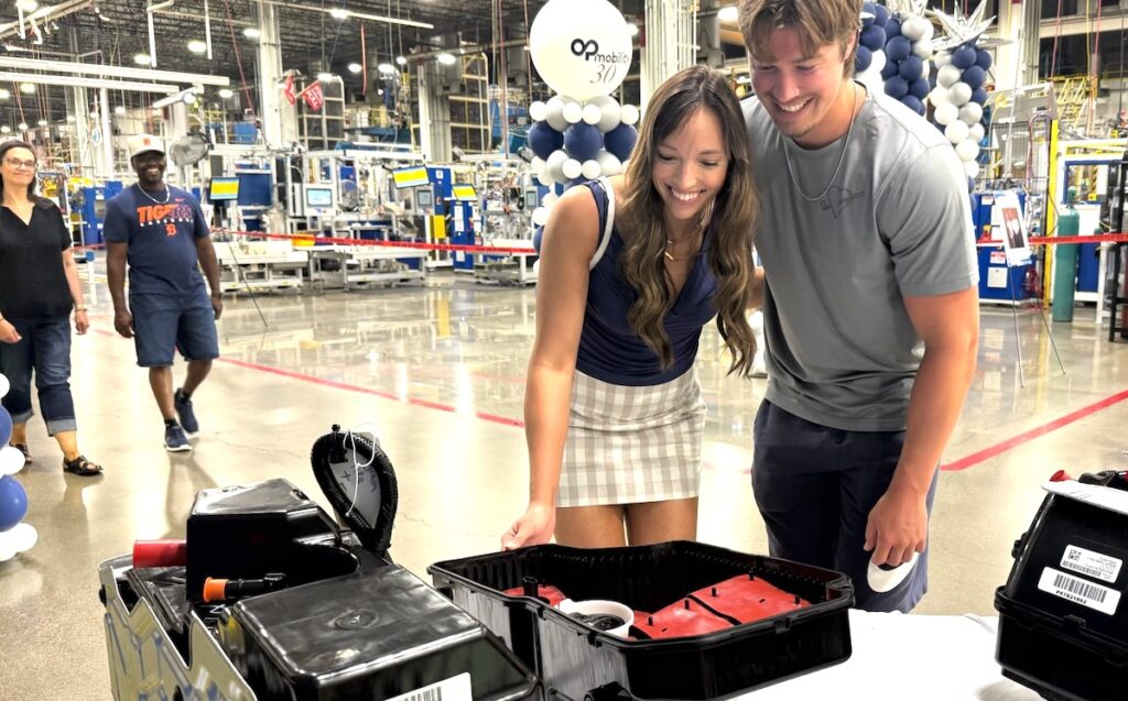 Brooke Johnson of Union City and her boyfriend, Justin Webster, look at the displays at OPmobility’s 30th anniversary open house on July 10. Webster is among the 300 employees at the plant.