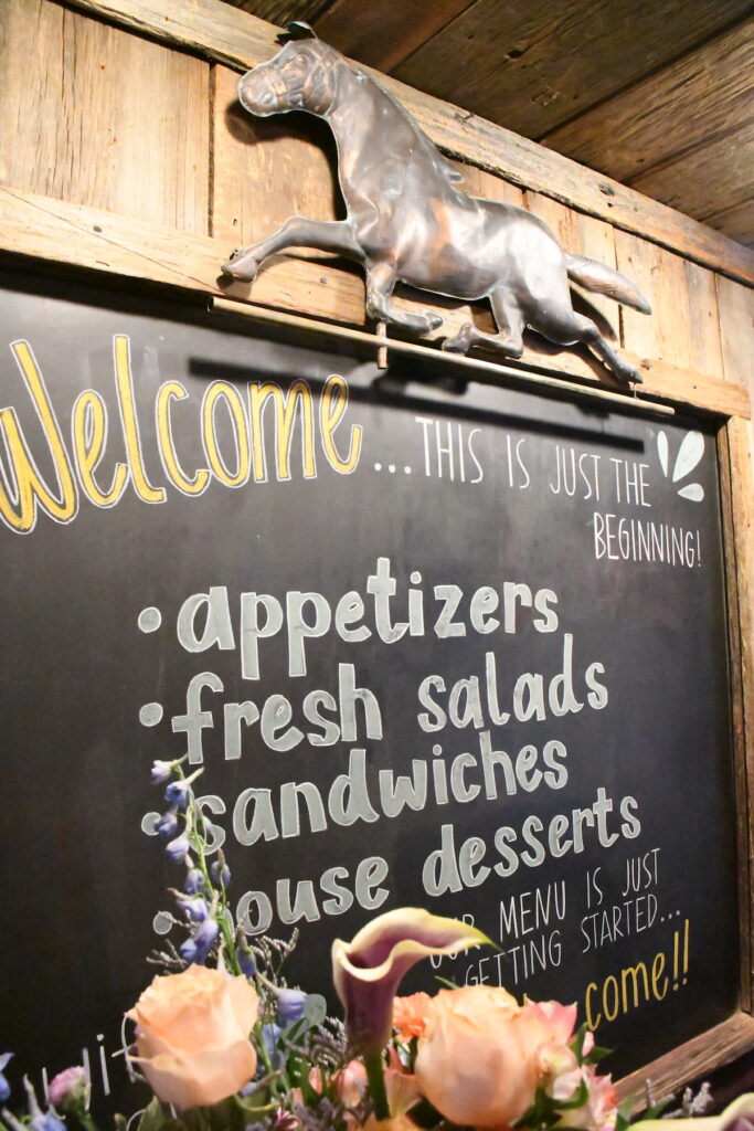 A blackboard welcoming guests to The Stable's July soft opening.