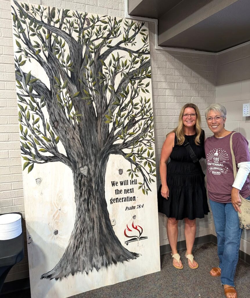 Angela Borton with Joy Garrow, who painted the tree mural next to them.
