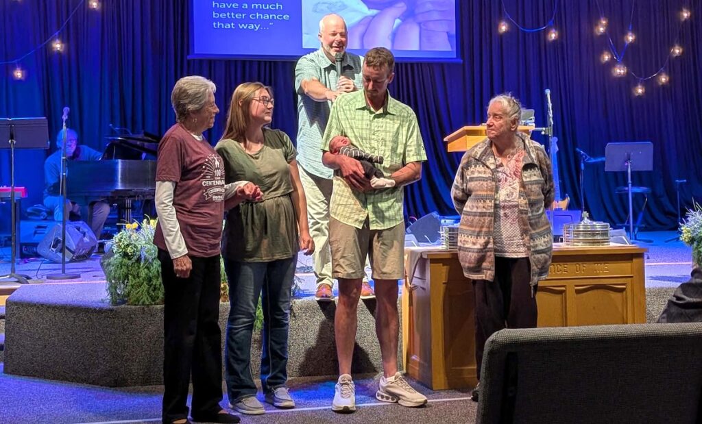 Pastor Vince Flippo, in the back, is pictured with Morenci Church of the Nazarene’s oldest and newest members. In the center are Megan and Isaiah Pruitt with their newborn, Maeve. On either side of them are Nancy Gandee, left, and Pat Schoonover.