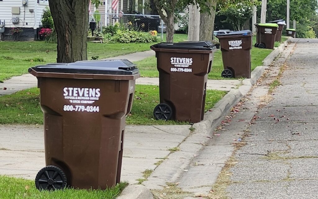 Trash pickup containers are lined up along the street on Sept. 9.