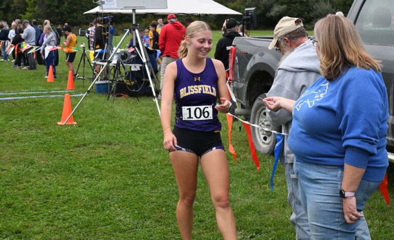 Blissfield’s Anna Hallett accepts the first-place medallion after winning the Al Navarro Invitational on Sept. 22 at Gerber Hill Park.